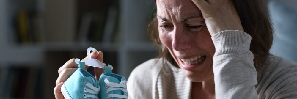 אישה עצובה לאחר מוות של תינוק אישה בוכה לאחר מוות של תינוק